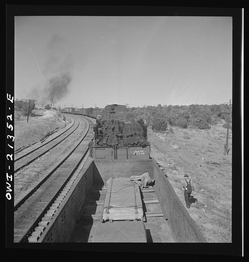 Yampai, Arizona. Brakeman and the conductor inspecting the train during a stop on the Atchison, Topeka, and Santa Fe Railroad between Seligman, Arizona and Needles, California
