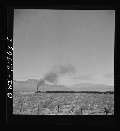 Untitled photo, possibly related to: Kingman (vicinity), Arizona. A train on the Atchison, Topeka and Santa Fe Railroad between Seligman, Arizona and Needles, California going around a curve in the Walapai flats