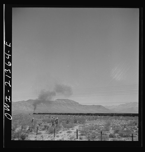Kingman (vicinity), Arizona. A train on the Atchison, Topeka and Santa Fe Railroad between Seligman, Arizona and Needles, California going around a curve in the Walapai flats