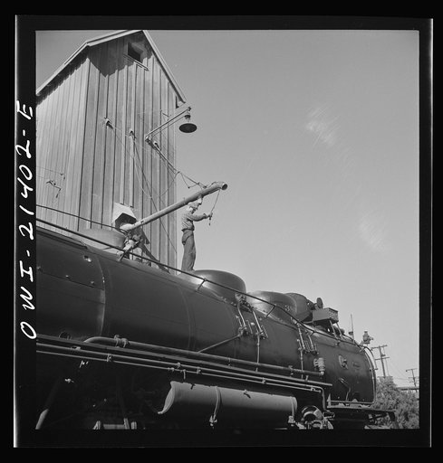 Untitled photo, possibly related to: Needles, California. Filling the sand dome of a locomotive near the roundhouse in the Atchison, Topeka, and Santa Fe Railroad yard