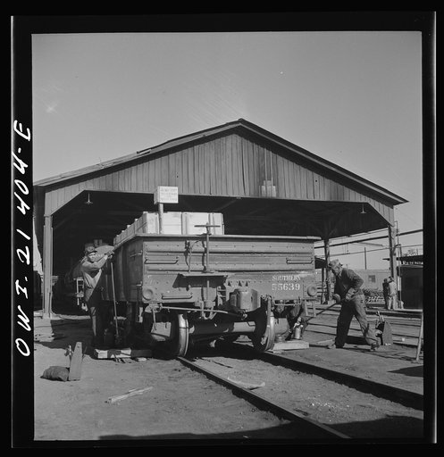 Needles, California. Workmen jacking up a car at the rip tracks in the Atchison, Topeka, and Santa Fe Railroad yard
