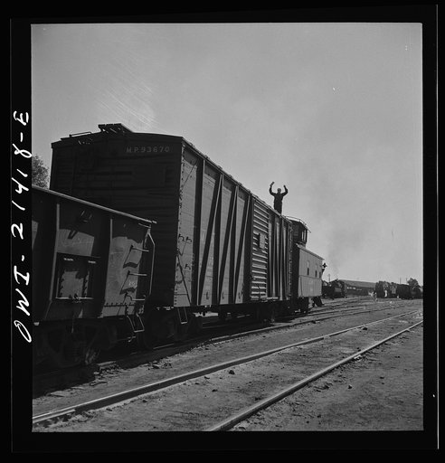 Needles, California. A brakeman giving the highball as the train is about to leave the Atchison, Topeka, and Santa Fe Railroad yard