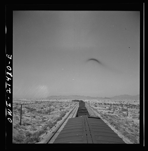 Untitled photo, possibly related to: The Atchison, Topeka, and Santa Fe Railroad train between Needles and Barstow, California cuts west across the Mojave Desert
