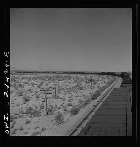 Goffs (vicinity), California. A diesel freight train going around a curve on the Atchison, Topeka, and Santa Fe Railroad between Needles and Barstow, California