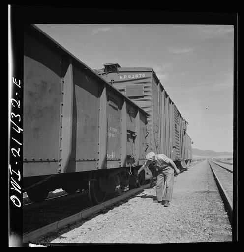 Ludlow, California. Conductor W.C. Scott inspecting his train on the Atchison, Topeka, and Santa Fe Railroad between Needles and Barstow, California