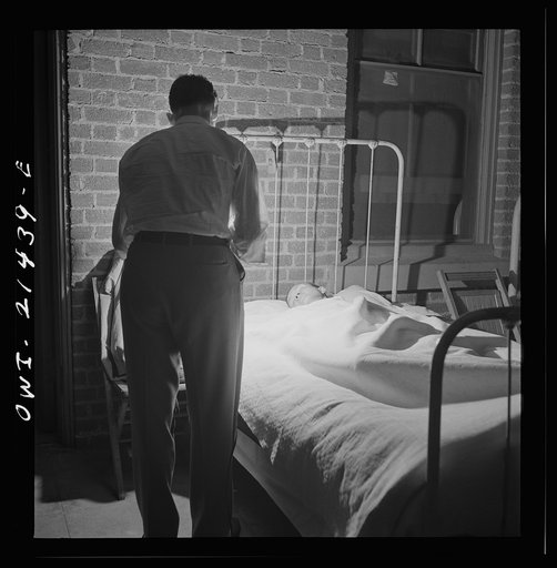 Barstow, California. Brakeman, Charles M. Dawes, being wakened to go to work by the caller at the reading room in the Atchison, Topeka, and Santa Fe Railroad yard