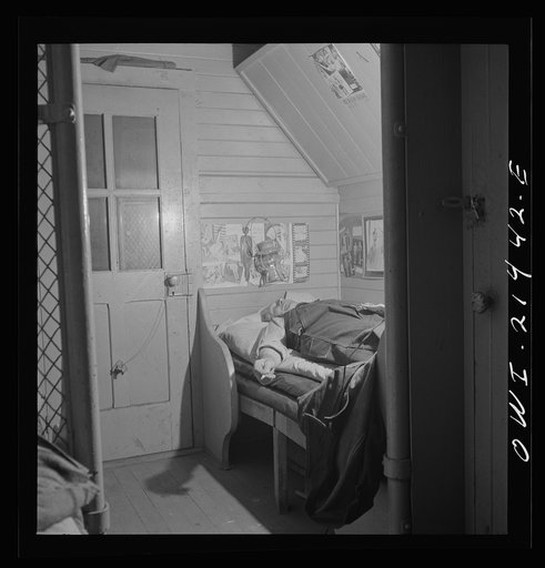 Barstow, California. A brakeman on the Atchison, Topkea and Santa Fe Railroad resting in his caboose at night