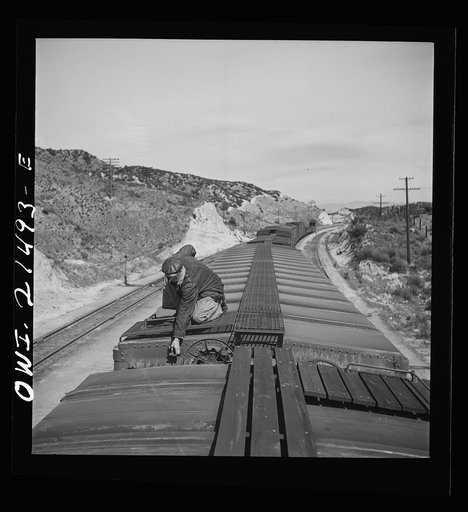 Summit, California. The brakeman opening the retainer valve on a car on the Atchison, Topeka and Santa Fe Railroad between Barstow and San Bernardino, California. From here to San Bernardino is one long downgrade of more than 2700 feet