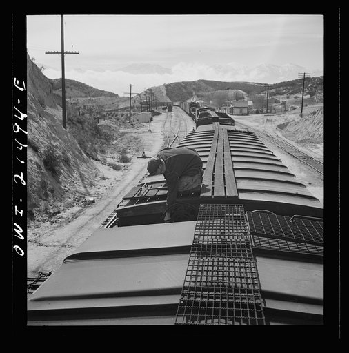 Untitled photo, possibly related to: Summit, California. The brakeman opening the retainer valve on a car on the Atchison, Topeka and Santa Fe Railroad between Barstow and San Bernardino, California. From here to San Bernardino is one long downgrade of more than 2700 feet