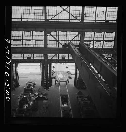Untitled photo, possibly related to: San Bernardino, California. Rolling in the wheels for an engine to be wheeled at the Atchison, Topeka, and Santa Fe Railroad locomotive shops