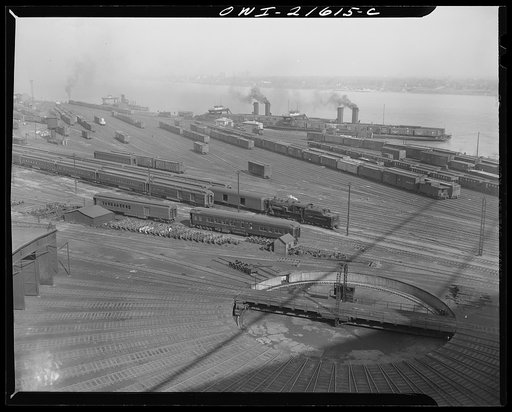 Detroit, Michigan (?). Looking down on a freight yard, showing a railroad turntable in the foreground and a car ferry in each of two docks in the background