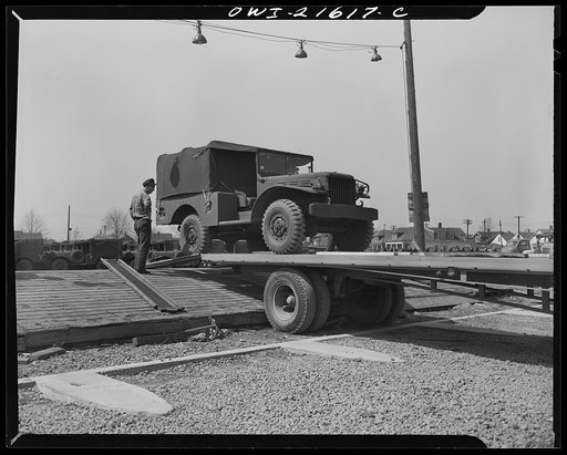 Detroit, Michigan. Driving army truck onto a haulaway truck
