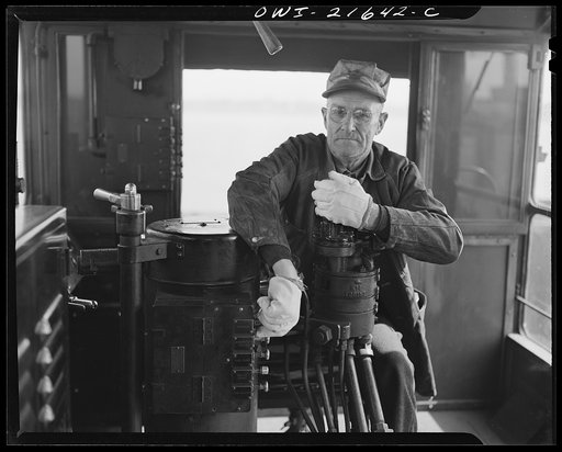 Detroit, Michigan. A diesel engineer in the cab of a locomotive