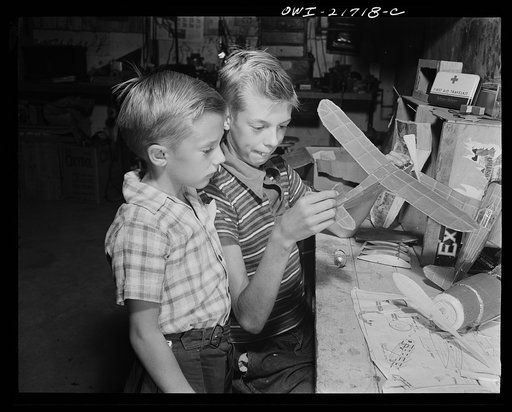 Rochester, New York. Earl and Howard Babcock looking over one of the model airplanes which Howard built