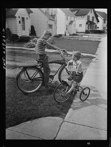 Rochester, New York. Howard and Earl Babcock playing in front of their house with their cycles
