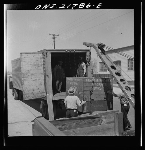 Untitled photo, possibly related to: Gunter Field, Alabama. Loading airplane motors onto a truck. They are being shipped to Macon, Georgia for repairs