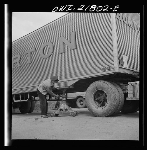 Untitled photo, possibly related to: Greenville, South Carolina. Loading platform at the terminal of the Associated Transport Company. Putting jacks under a trailer so the tractor can move off to another trailer