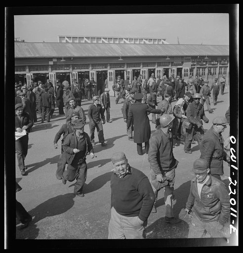 Baltimore, Maryland. Workers hurrying to catch a trolley and a trackless trolley at seven a.m.