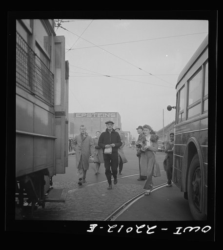 Baltimore, Maryland. Workers hurrying to catch a trolley and a trackless trolley at seven a.m.