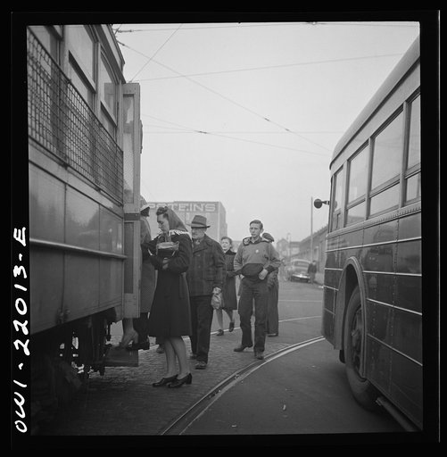 Untitled photo, possibly related to: Baltimore, Maryland. Workers hurrying to catch a trolley and a trackless trolley at seven a.m.