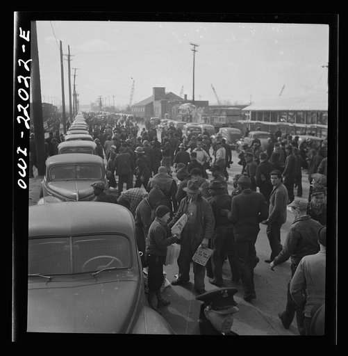 Baltimore, Maryland. Second shift workers leaving the Bethlehem Fairfield shipyard at three p.m. making a dash for cars parked along the road