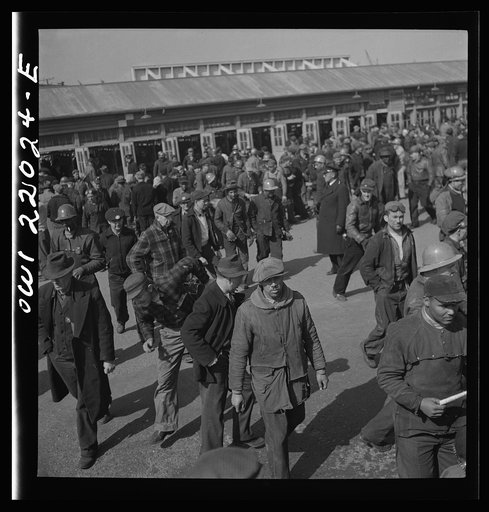 Untitled photo, possibly related to: Baltimore, Maryland. Workmen of the second shift of the Bethlehem Fairfield shipyard lining up at the gate waiting to get on trolleys at three p.m.