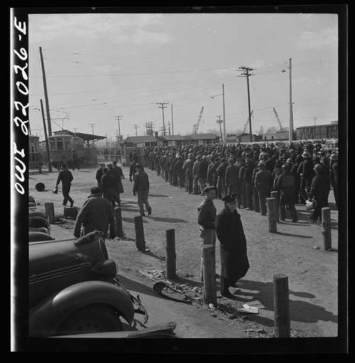 Baltimore, Maryland. Workmen of the second shift of the Bethlehem Fairfield shipyard lining up at the gate waiting to get on trolleys at three p.m.