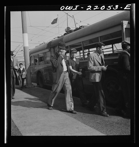 Untitled photo, possibly related to: Baltimore, Maryland. Workers boarding a trackless trolley at four p.m. Trackless trolleys are more economical than buses to run because they require no gas; but do use tires. They are run by electric power in wires above the street and can be manipulated from one