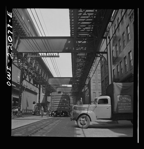 Baltimore, Maryland. Trucks and trains unloading goods underneath an elevated trolley