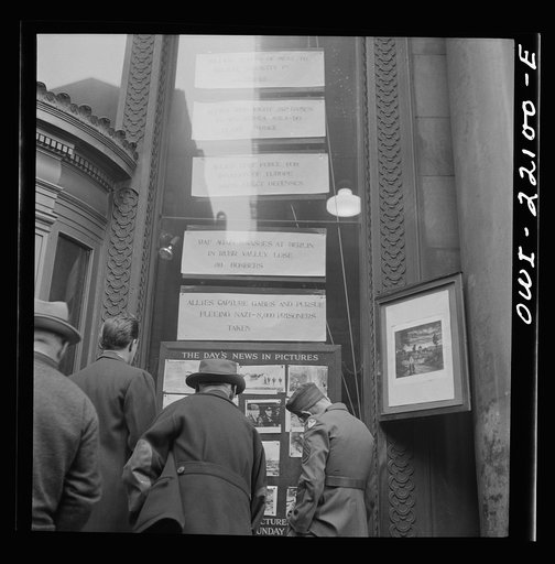 Baltimore, Maryland. Reading news bulletins and looking at the news pictures outside the Baltimore News building