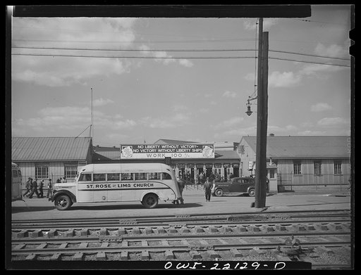 Baltimore, Maryland. Every available bus in Baltimore has been pressed into service to fill wartime transportation needs. A church bus is waiting outside the Bethlehem Fairfield shipyard gates before three o'clock whistle
