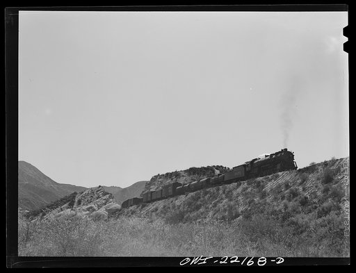 Eastbound Atchison, Topeka, and Santa Fe Railroad freight train near Cajon, California climbing the steep grade from San Bernardino to Summit