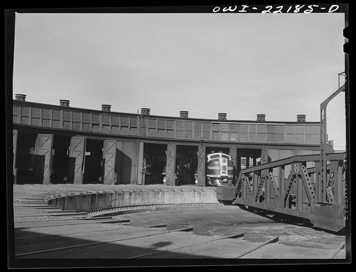 Winslow, Arizona. Atchison, Topeka and Santa Fe Railroad diesel freight engine coming out of the roundhouse. The entire engine consists of four units, only two of which can be accomodated in a stall at the roundhouse or on the turntable