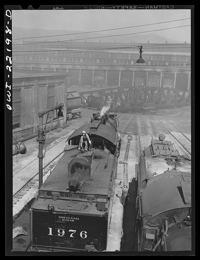Untitled photo, possibly related to: San Bernardino, California. At the Atchison, Topeka and Santa Fe Railroad roundhouse. Note women workers who are employed as "suppliers" taking lamps and oil cans off an engine after a trip and replacing them