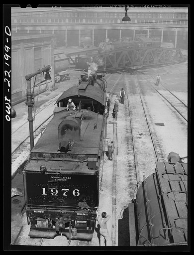 San Bernardino, California. At the Atchison, Topeka and Santa Fe Railroad roundhouse. Note women workers who are employed as "suppliers" taking lamps and oil cans off an engine after a trip and replacing them