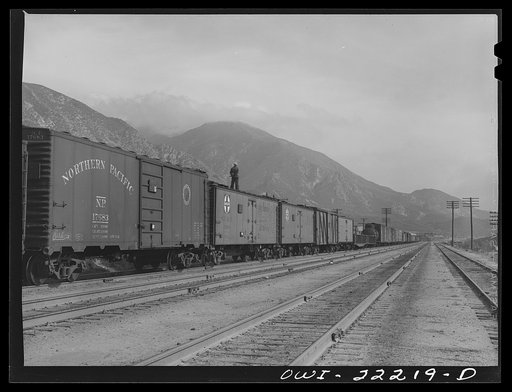 Untitled photo, possibly related to: Cajon, California. Swing brakeman riding on top of the Atchison, Topeka, and Santa Fe Railroad train. Brakemen ride the trains in this way during the entire descent from Summit to San Bernardino