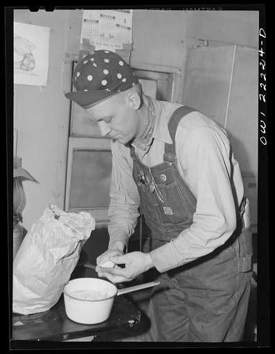 Atchison, Topeka, and Santa Fe Railroad. Brakeman L.E. Capsey preparing a meal in the caboose enroute to Gallup, New Mexico