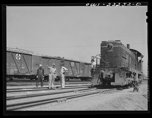 San Bernardino, California. Yard crew working with a Atchison, Topeka, and Santa Fe Railroad diesel switch engine