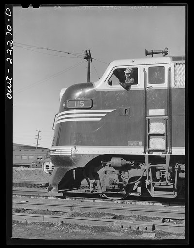Winslow, Arizona. Fireman in the cab of a Atchison, Topeka, and Santa Fe Railroad diesel freight locomotive which has just come out of the roundhouse