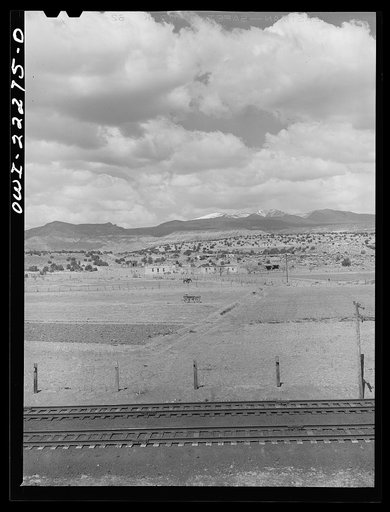 Indian farms and houses near Laguna, New Mexico enroute to Gallup on the Atchison, Topeka, and Santa Fe Railroad. In the background is Mount Taylor