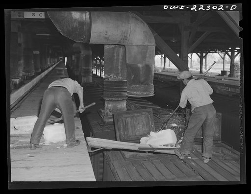 Untitled photo, possibly related to: San Bernardino, California. Worker removing an air duct from a Atchison, Topeka and Santa Fe Railroad refrigerator car at the precooling plant