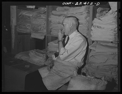 Philadelphia, Pennsylvania. A worker eating his lunch in front of empty seed bags at the W. Atlee Burpee Company, seed dealers
