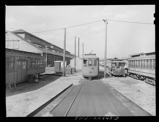 Baltimore, Maryland. The yard of the Washington terminal, maintenance plant of the Baltimore Transit Company. From left to right: old trolley made into a smoker for employees; a work car; and old horse car. The Baltimore Trust building on the horizon