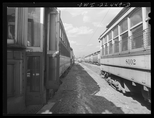Baltimore, Maryland. Trolley junk in the yard at the Washington terminal, maintenance plant of the Baltimore Transit Company. Most of these trolleys can be reconditioned for use if wartime needs so require. In the distance are trackless trolleys