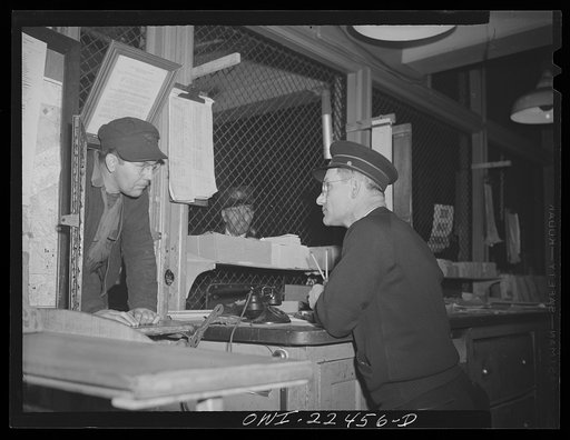 Baltimore, Maryland. Trolley dispatcher in his cage at the Park Terminal listening to a report of the engineer on the condition of a car. Each car receives a routine checkup daily