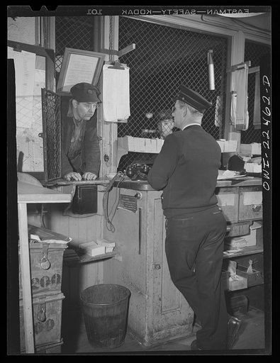 Untitled photo, possibly related to: Baltimore, Maryland. Trolley dispatcher in his cage at the Park Terminal listening to a report of the engineer on the condition of a car. Each car receives a routine checkup daily