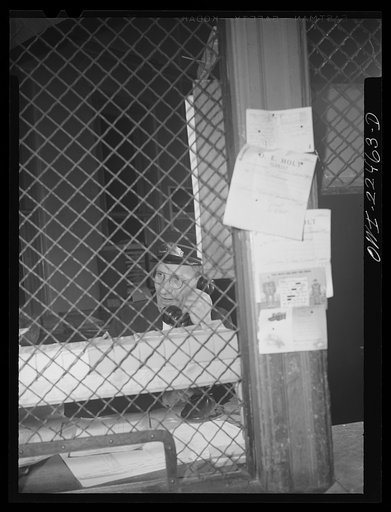 Untitled photo, possibly related to: Baltimore, Maryland. Trolley dispatcher in his cage at the Park Terminal listening to a report of the engineer on the condition of a car. Each car receives a routine checkup daily