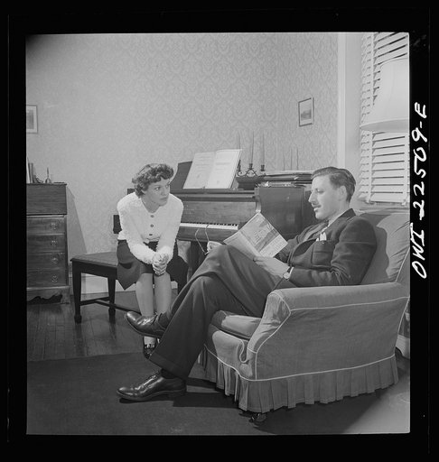 Swedish-American foreman at the SKF roller bearing plant reads to his Italian-American wife at home. Philadelphia, Pennsylvania