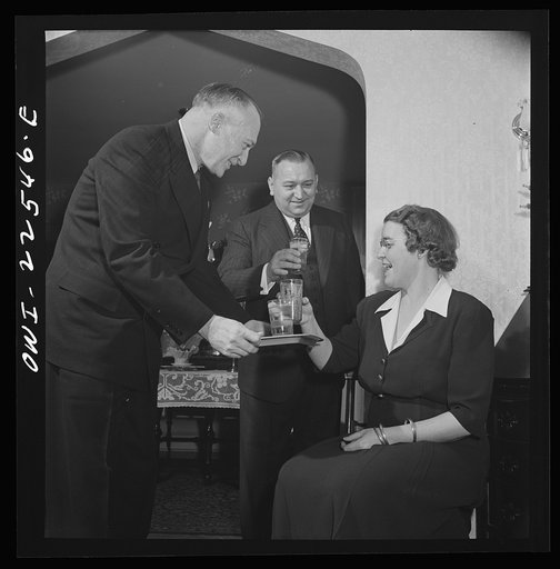 Philadelphia, Pennsylvania. Swedish-American executive of the SKF roller bearing factory serving drinks to his wife and a friend