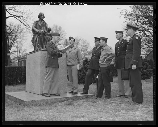 Charlottesville, Virginia. Officers enroute to class pausing beside the statue of Thomas Jefferson, founder of the University of Virginia, where the United States Army holds the School of Military Government